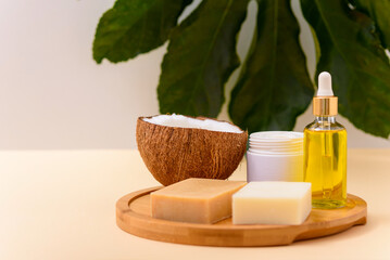 handmade organic cosmetics, natural soap, massage oil, cream on wooden board on beige background