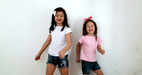 Children dancing to camera for social media, two little sisters dance