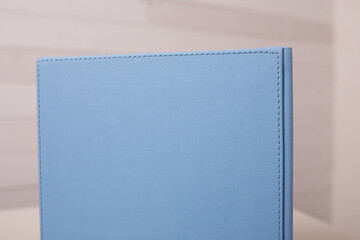 Spine of book, photobook, notebook or photoalbum in light blue leather cover on white background.