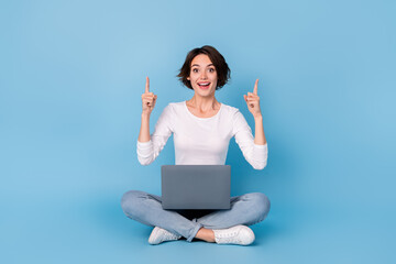 Photo of cute excited lady dressed white shirt legs crossed empty space typing modern device isolated blue color background