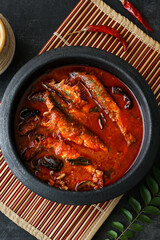 Top view of Sardine fish curry hot spicy Kerala masala fish curry for rice India Indian food red chili curry leaf Asian cuisine. Bengali Goan red fish curry coconut milk, mango clay pot Sri Lanka
