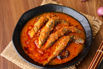 Top view of Sardine fish curry hot spicy Kerala masala fish curry for rice India Indian food red chili curry leaf Asian cuisine. Bengali Goan red fish curry coconut milk, mango clay pot Sri Lanka