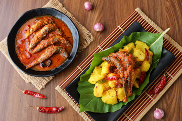 tapioca and spicy hot Kerala fish curry Indian food on banana leaf. Kappa sardine masala fish curry. Asian cuisine Bengali macher Jhal Goan fish curry in coconut milk cassava Sri Lanaka Tamil nadu