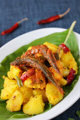 tapioca and spicy hot Kerala fish curry Indian food on banana leaf. Kappa sardine masala fish curry. Asian cuisine Bengali macher Jhal Goan fish curry in coconut milk cassava Sri Lanaka Tamil nadu