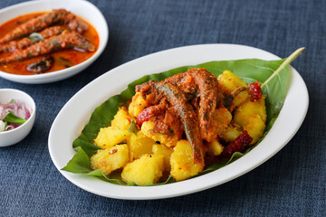 tapioca and spicy hot Kerala fish curry Indian food on banana leaf. Kappa sardine masala fish...