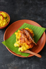 tapioca and spicy hot Kerala fish curry Indian food on banana leaf. Kappa sardine masala fish curry. Asian cuisine Bengali macher Jhal Goan fish curry in coconut milk cassava Sri Lanaka Tamil nadu