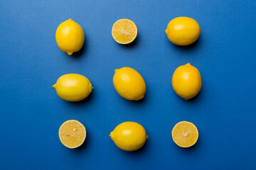 Many fresh ripe lemons as colored background, top view. Elegant background of lemon and lemon slices Top view flat lay
