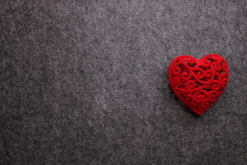 Conceptual dark gray background for Valentine's Day with a red heart with free space for an inscription.