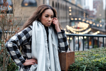 Portrait of young black woman in a cold winter day looking away.
