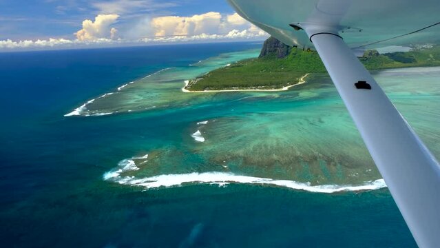View of mauritius ocean coast, underwater watefall and Le Morne mountain from float plane cabin