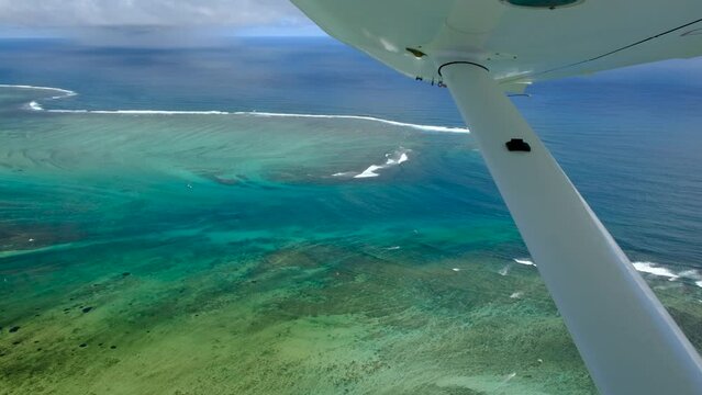 View of mauritius ocean coast, underwater watefall and Le Morne mountain from float plane cabin
