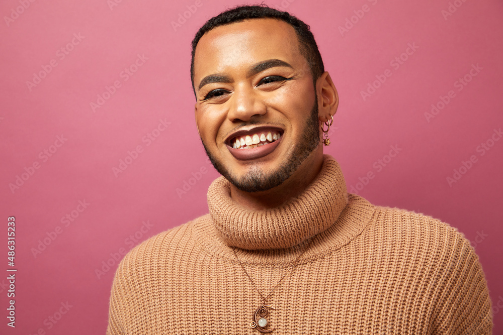 Wall mural studio portrait of smiling queer man against purple background