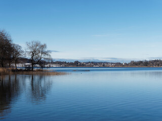 Lac de Haute-Bavière. Vue sur le lac de tegern et à l'horizon, la plage de Kaltenbrunn à Gmund am Tegernsee et le clocher de l'église St. Ägidius depuis la jetée et la promenade du lac à Bad Wiessee