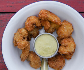 Top view of fried breaded shrimps with avocado mayonnaise and lemon.