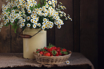Country still life with daisies and strawberries.