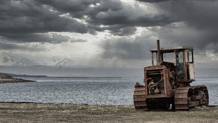 rusted bulldozer stands on the beach