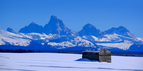 Tetons Mountains in Winter with Old Cabin Homestead Building