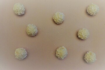 Weiße Pralinen auf rosa Fläche