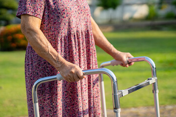 Obraz premium Asian senior or elderly old lady woman use walker with strong health while walking at park in happy fresh holiday.