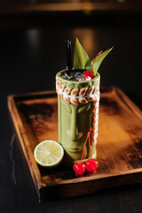 Tiki cocktail garnished with lime and cherry. Refreshing alcoholic drink.