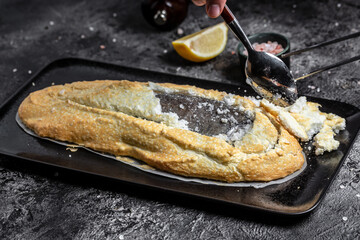 Fish covered in meringue salt. Tray with fish and lemon. Breaded river trout fish. New recipe of delicious fish. still life. top view. Healthy food