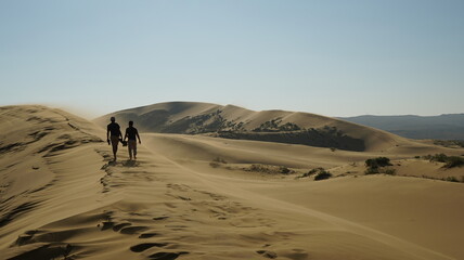 Two men walking on sand dune