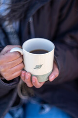 Woman holding mug with hot drink