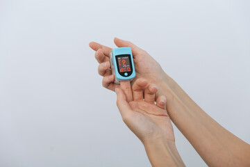 Pulse oximeter with hand of doctor isolated on white. Measuring oxygen saturation, pulse rate and oxygen levels. The concept of portable digital device to measure person's oxygen saturation.