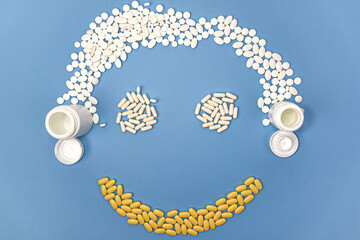 Medical pills, tablets, capsules and drug bottles arranged into a smiley face. Health care and...