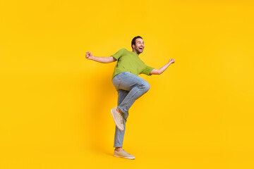 Fototapeta na wymiar Full body profile side photo of young man good mood dancing look empty space isolated over yellow color background
