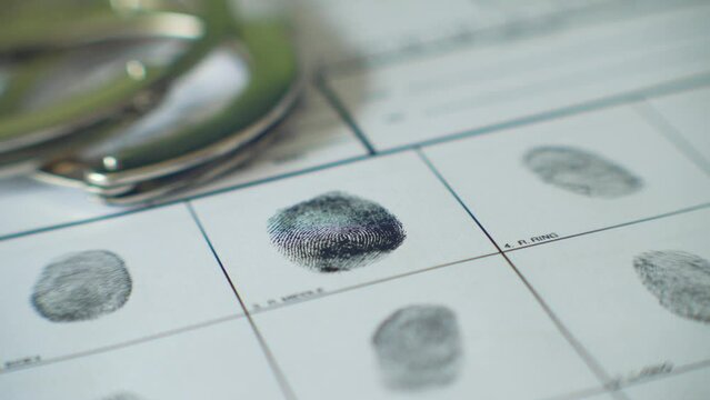 Close up of a man and woman having his fingerprints taken at the police station