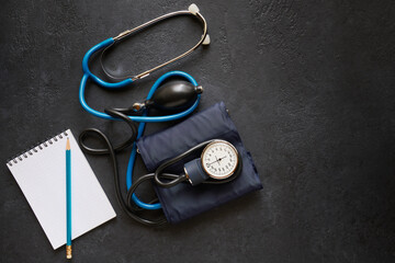 Diagnostic and monitoring concept, sphygmomanometer for measuring blood pressure and notebook for recording data, black background with space for text
