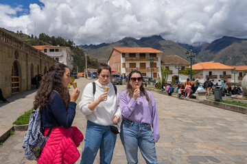 Three women eating ice cream on the street of a traditional andean town