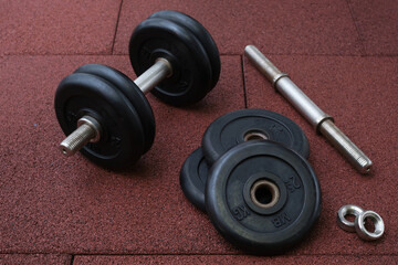 Naklejka na ściany i meble dumbbell and iron plates on the rubber floor in the gym. Bodybuilding equipment. Fitness or bodybuilding concept background.