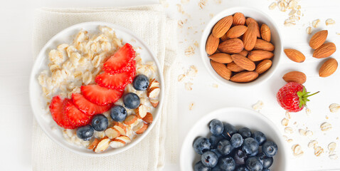 Oatmeal porridge with strawberry, blueberries and nuts in bowl