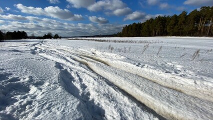 Fototapeta na wymiar Winter dirt road along the forest. Winter landscape.