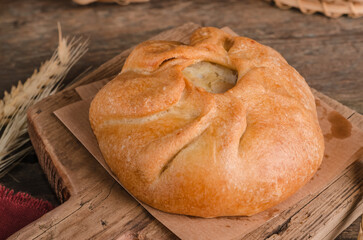 Appetizing fresh culinary pastry - beautiful curly pie with filling on wooden