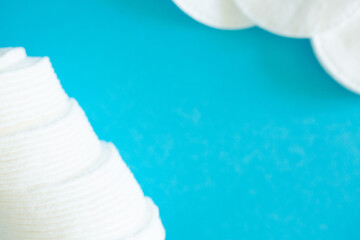 Cotton pads and ear sticks for hygiene on a blue background. The concept of clean face and body. Bath amenities for hygiene. Flat layout with copy space.