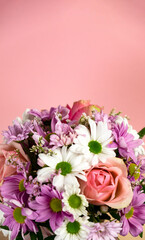 Beautiful bouquet of flowers on a pink background. Roses, white and pink chrysanthemums. Place for text