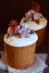 Glazed easter cake decorated with meringues, macaroons and candies on dark background, copy space. Happy Easter holidays. Kulich