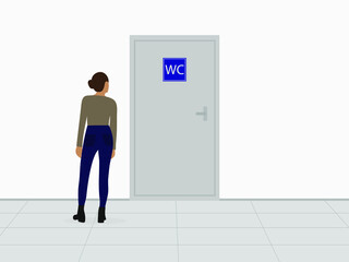 Female character stands in front of the door to the toilet indoors