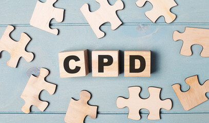 Blank puzzles and wooden cubes with the text CPD Continuing Professional Development lie on a light blue background.