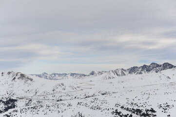 Fototapeta na wymiar Pyrenees mountains range in winter with snowy peaks in Grandvalira ski paradise resort in Andorra