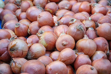 Stack of onions on the market stall. Fresh organic onions in the traditional Turkish bazaar. Group of raw onions. Pile of onions on the table