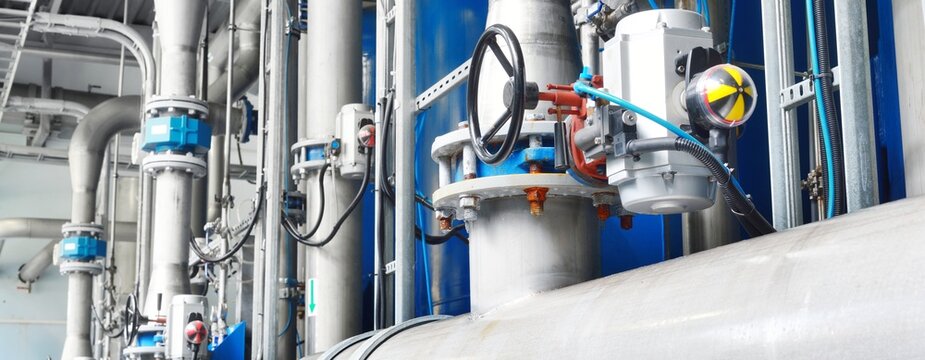Large industrial water treatment and boiler room. Piping, valves, flanges