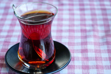 Traditional Turkish tea on the red striped tablecloth. Close up of tea.