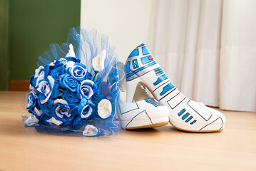 A closeup of the white high heel shoes with a blue bouquet