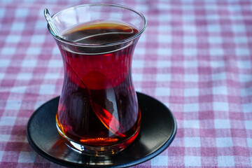 Traditional Turkish tea on the red striped tablecloth. Close up of tea.