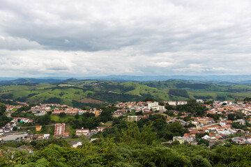 Cidade panorâmica do interior do País, com montanhas ao fundo e céu nublado