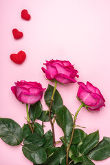 pink roses and knitted hearts on a pink background